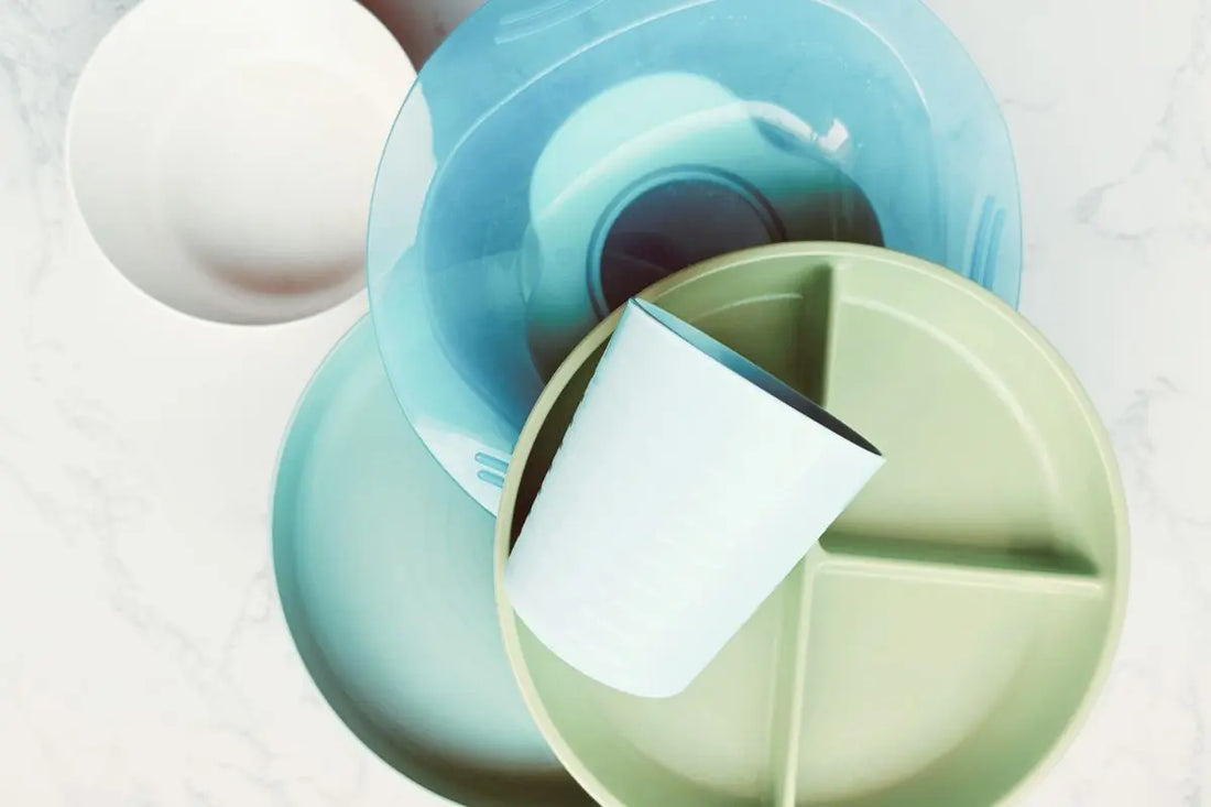 Top view of a stack of plastic plates, bowls, and cups, symbolizing concerns about plastic usage, health risks, and the myths surrounding BPA-free products for a blog post on 'Our Plastic Problem: Health Risks, BPA-Free Myths and Greenvyne's mission.