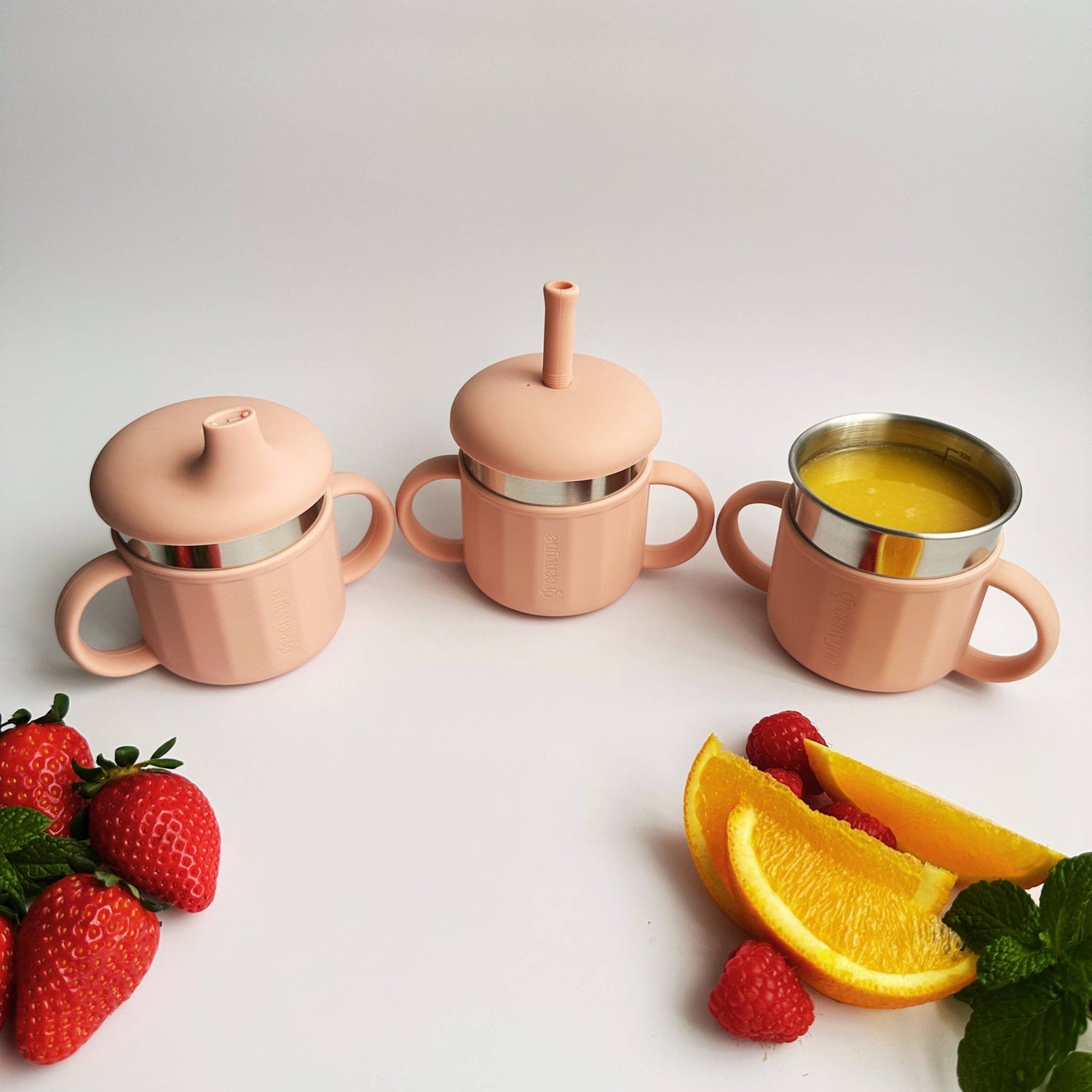 Kids 3 in 1 stainless steel sippy cup showing soft spout, straw and open cup option on table - Greenvyne