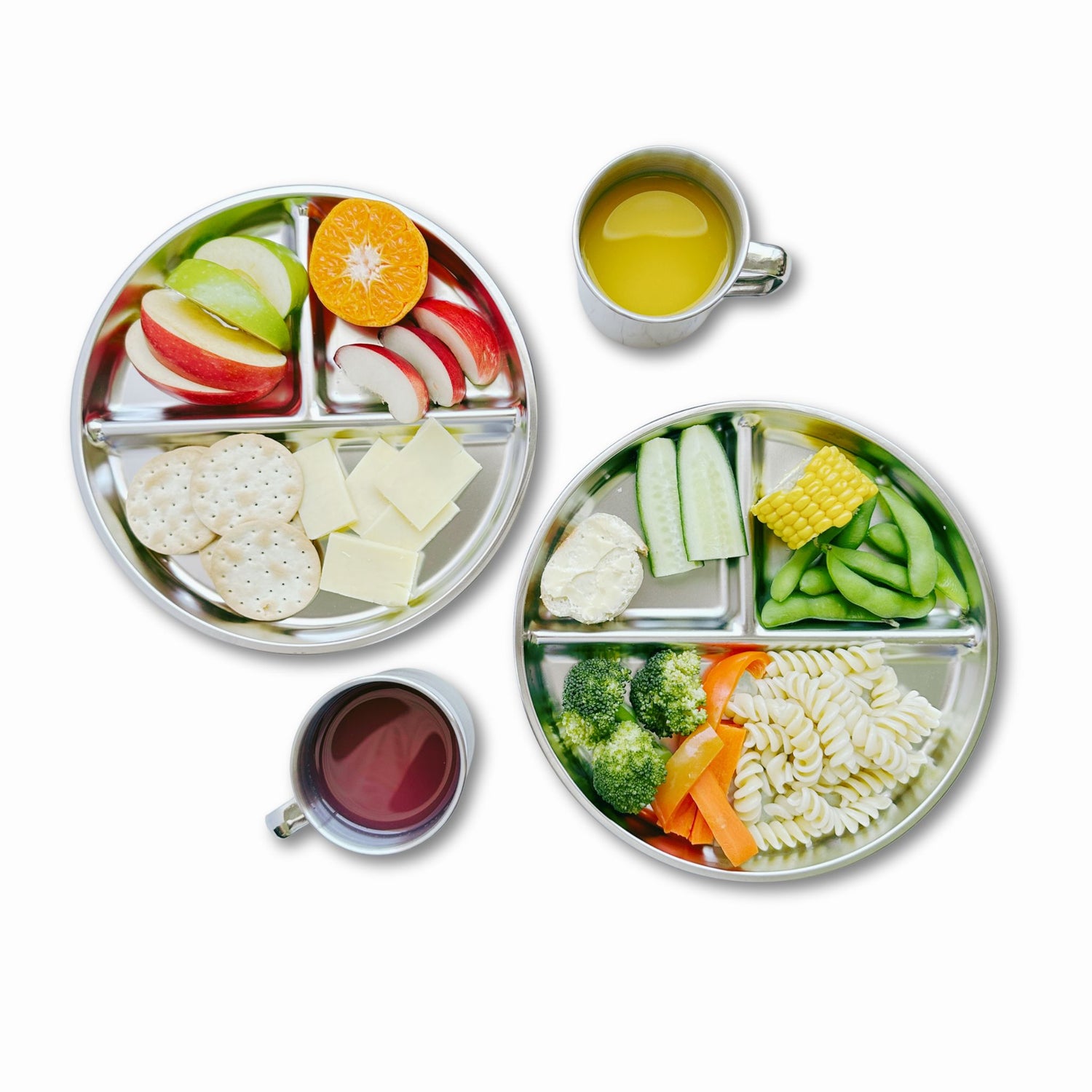 Top view of two kids' stainless steel divided plates filled with food and two 250ml mugs with juice on a table, showcasing eco-friendly mealtime essentials for babies and toddlers.
