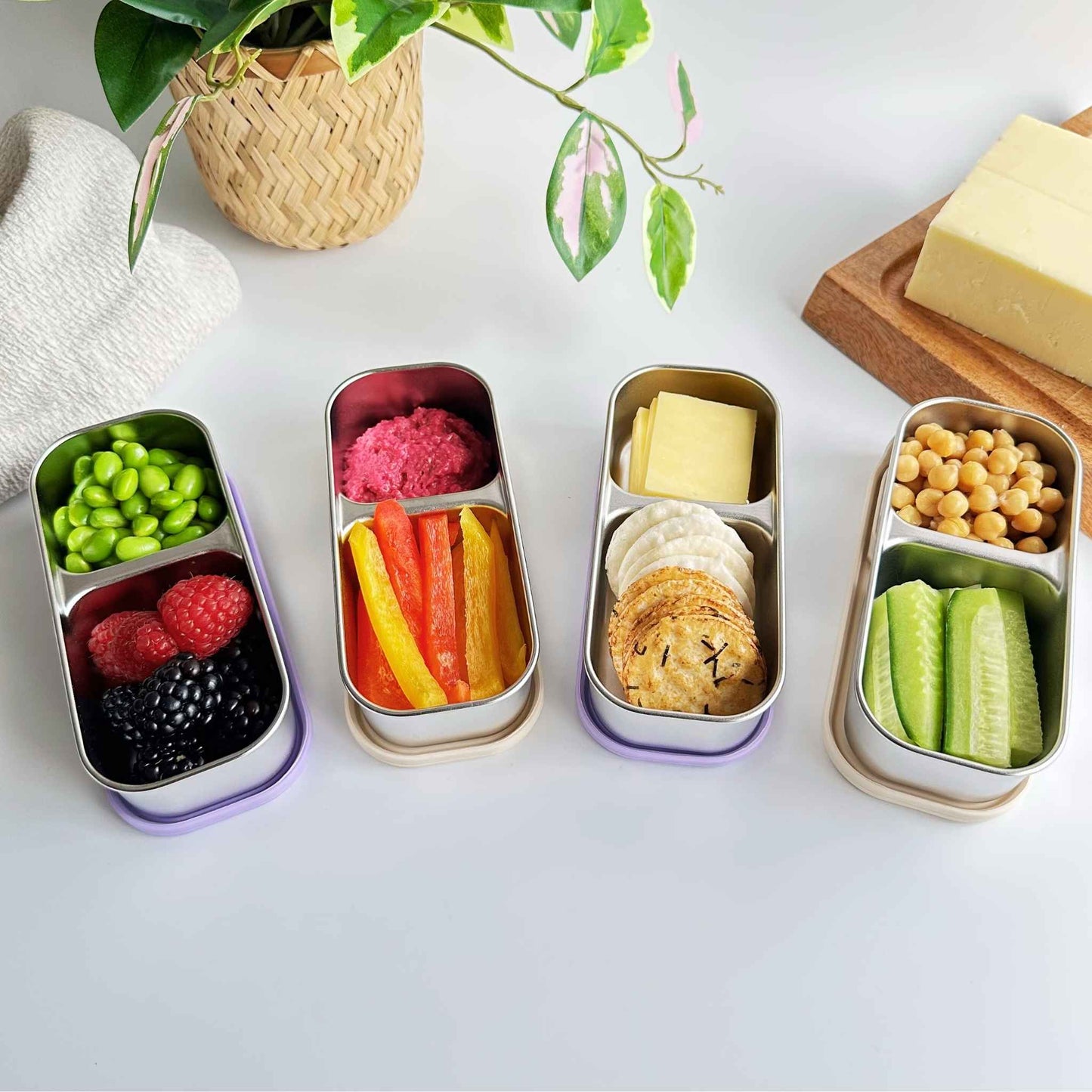 Greenvyne snack container stainless steel with various snacks on a table.