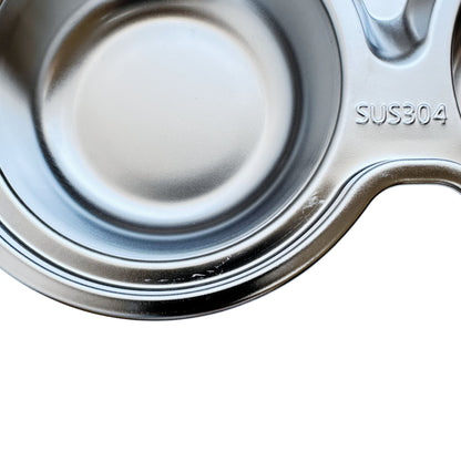 Close-up view of imperfections on a kid's stainless steel seconds car-shaped plate with suction.