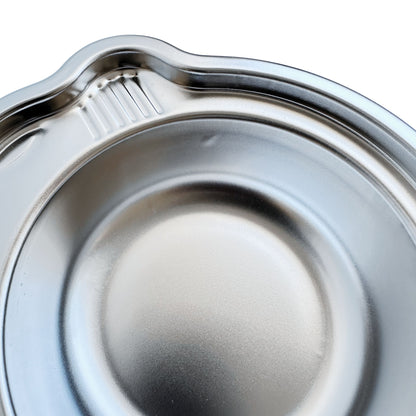 Close-up view of imperfections on a kid's stainless steel seconds car-shaped plate with suction.
