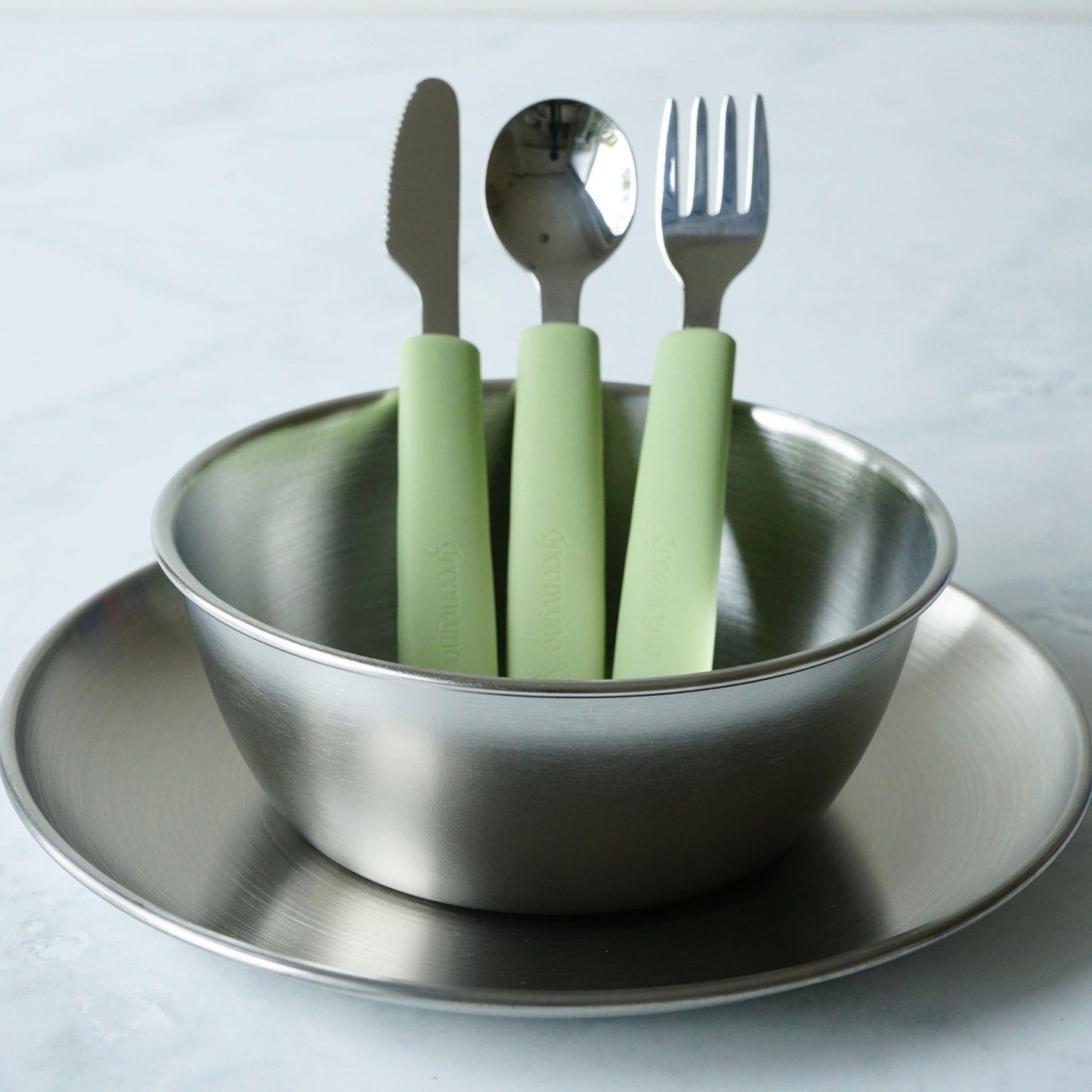 Greenvyne toddler and kids' stainless steel meal time set with plate, bowl and spoon with green silicone handle.