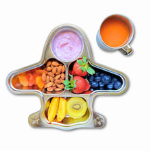 Top view of a kids' stainless steel airplane plate filled with fruits, nuts, and yogurt, alongside a 250ml stainless steel mug with juice, showcasing a fun and eco-friendly mealtime setup.
