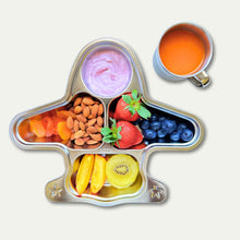 Top view of a kids' stainless steel airplane plate filled with fruits, nuts, and yogurt, alongside a 250ml stainless steel mug with juice, showcasing a fun and eco-friendly mealtime setup.