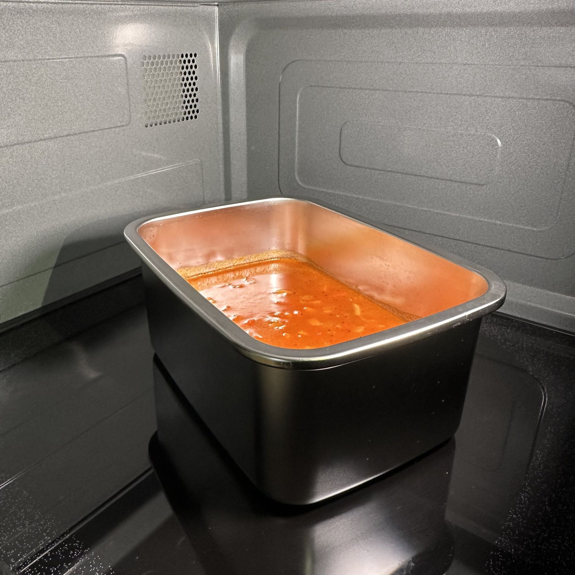 Stainless steel 304 grade food storage container in a microwave with pasta reheating. BPA, phthalates and microplastic free. Greenvyne.