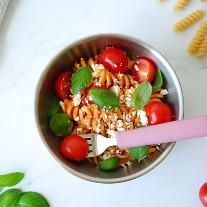 Greenvyne toddler and kids' fork stainless steel with dark rose silicone handle on a bowl with pasta.